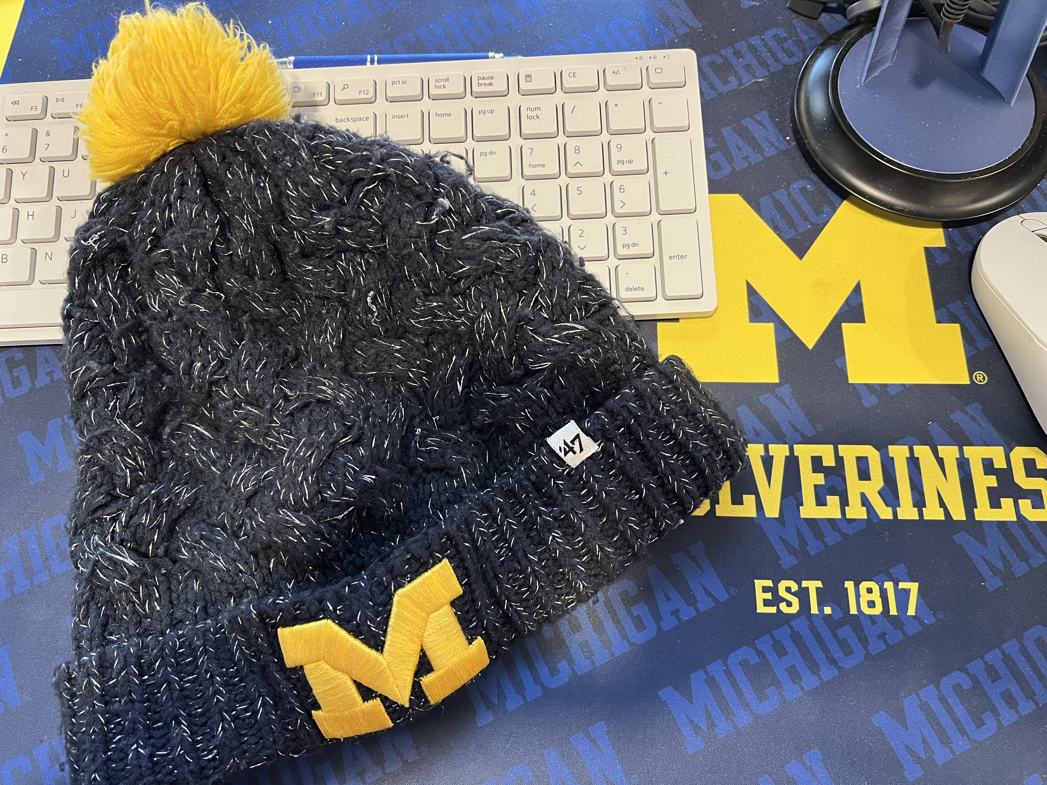 University of Michigan knit cap rests on a Michigan deskpad